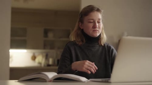 Exhausted Young Woman with Cerebral Palsy Struggling to Stay Awake While Studying Late at Night