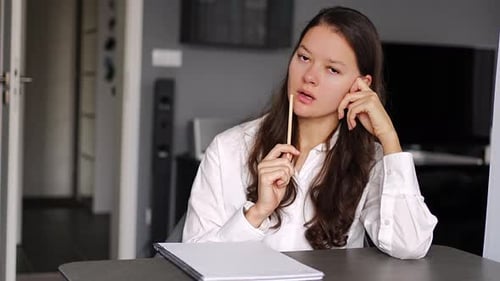 Young Woman Writing Something on the Diary Book While Sitting on the Armchair at Home