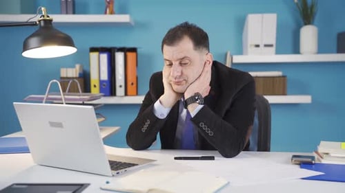 Bored businessman in the office does not want to work.