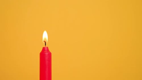 Red Candle on Yellow Background