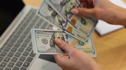 Counting Cash Money in front of Laptop