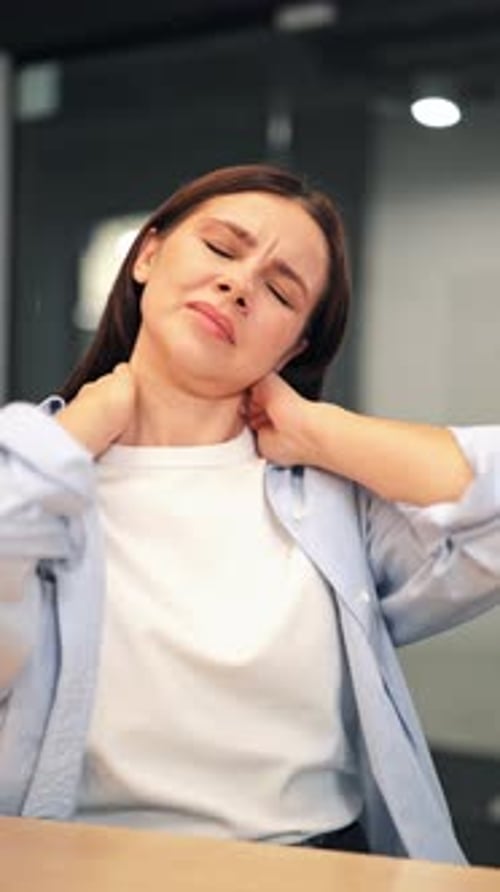 Woman Massaging Stiff Neck at Her Desk