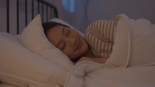 Asian beautiful woman lying down on bed in bedroom, dreaming at night.