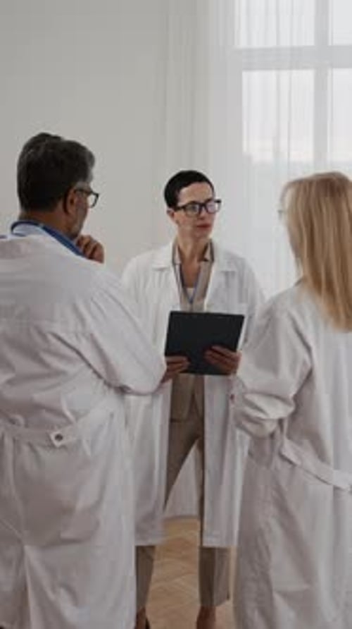 Medical Professionals Discussing Information in Hospital Room