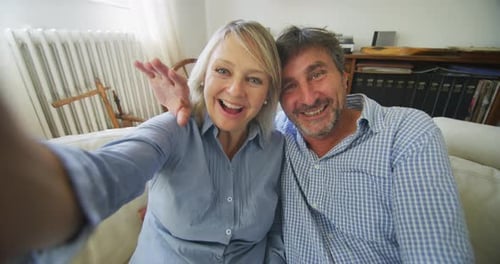 Happy Couple Taking Selfie Waving to Camera at Home