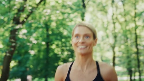 Smiling Athletic Woman Jogging Outdoors in Green Park