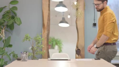 Man Arriving at Desk and Opening Laptop
