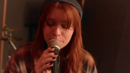 Redheaded Girl Singing in Microphone, Playing in Punk Band in Music Studio