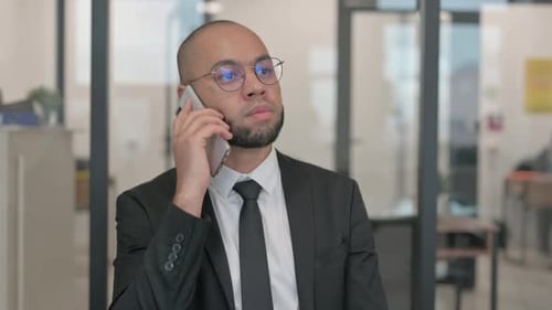 Man in Suit Using Phone in Modern Office