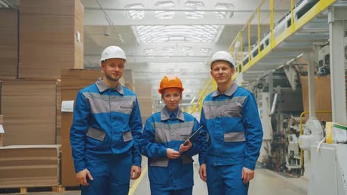 Factory Workers Smiling in an Industrial Setting