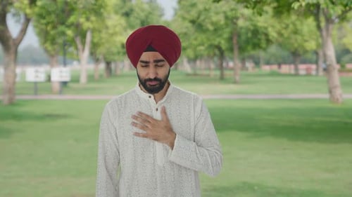 Sick Sikh Indian man suffering from fever in park