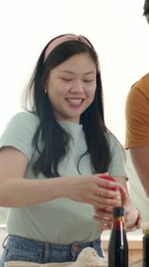 Vídeo vertical: Alcanzando una bolsa de malla, ella con la parte superior verde desempacando en la cocina comprobando la tapa roja en busca de etiqueta