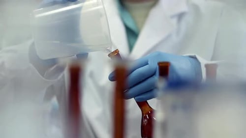 Scientist working with chemical reaction in chemistry research lab in glass flask