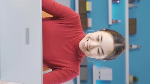 Vertical Video of Asian woman working in home office working from laptop in happy and moody mood.