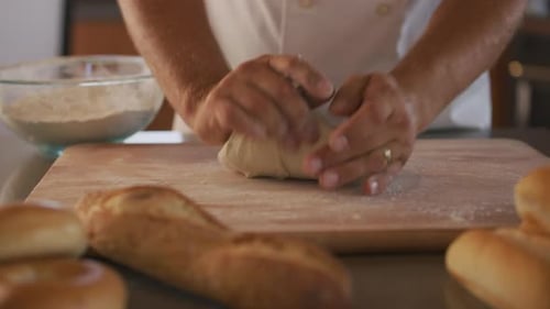 Chef Kneading Bread Dough at Bakery Baker