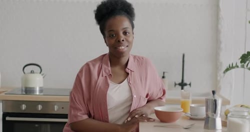 Woman Smiling with Breakfast at the Kitchen Counter