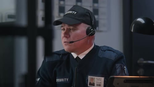 Security Officer Communicating Over the Radio in Office