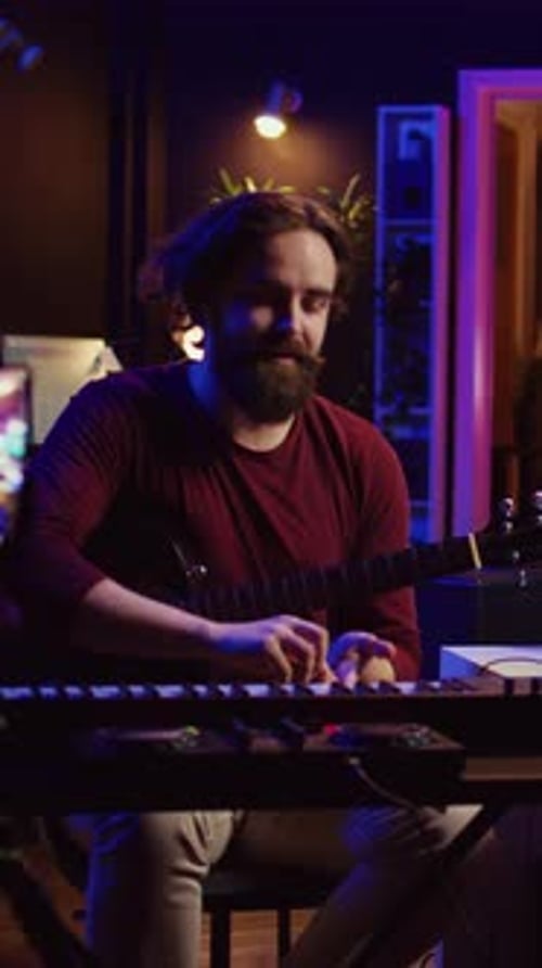 Man Playing Guitar in Dimly Lit Room