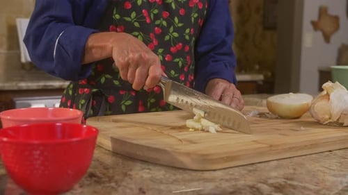 Woman's chopping vegetables on a cutting board to prepare for cooking