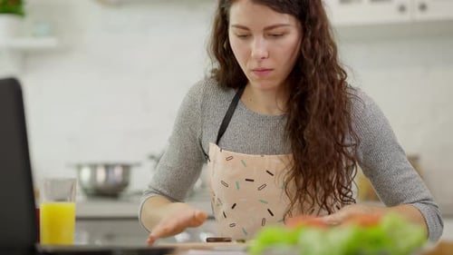 Woman Cooking and Video Calling in Bright Kitchen