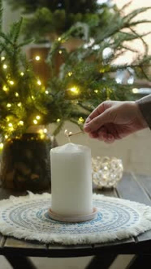 Vertical Video Hand Lights Candle Vase with Christmas Tree Branches on Background