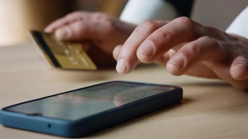 Unbekannter Mann gibt Kreditkartendaten in die Smartphone-App ein, um sicher online zu bezahlen