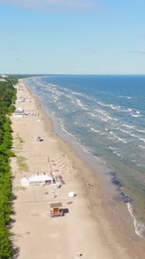 Aerial Drone Footage of Jurmala's Scenic Baltic Beach with Waves, vertical