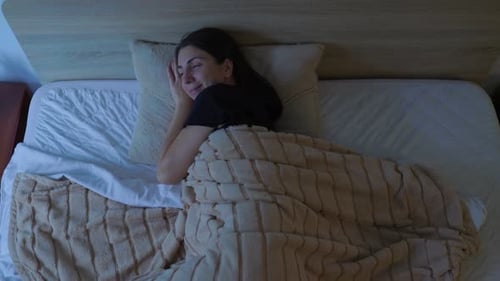 Woman Smiling Lying Awake in Bed at Night