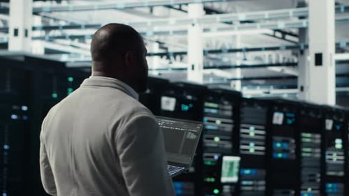 Engineer Walking in Server Farm Automating System Diagnostics