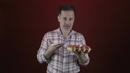 Man Holding Carton of Eggs, Selects One