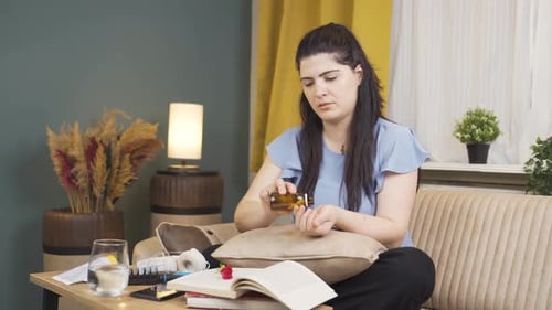Woman Taking Medicine With Water at Home