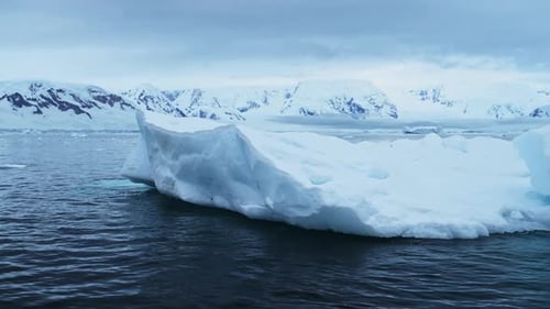 Eisberg, der im Meer auf See schwimmt, mit antarktischen Bergen an der Küste der antarktischen Halbinsel, wunderschönes D