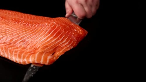 Fresh Salmon Piece Being Cut with Knife
