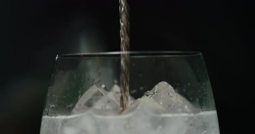 Drink Being Poured into Glass with Ice