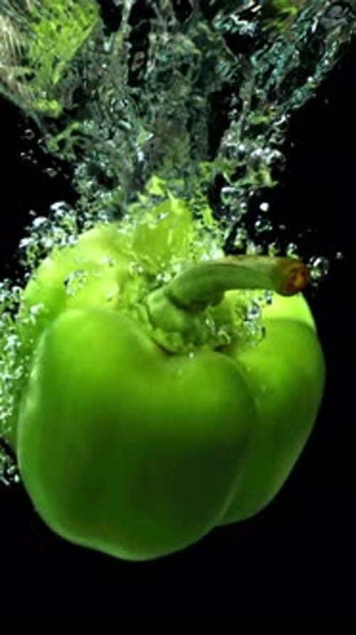 Green Sweet Pepper fällt unter Wasser, gefilmt mit einer Hochgeschwindigkeitskamera mit 1000 Bildern pro Sekunde