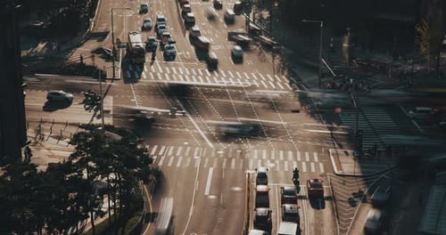 Busy Urban Intersection with Flowing Traffic and Pedestrians Crossing Streets Showcasing Dynamic