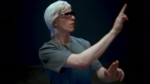 Man with white hair in futuristic eyewear gesturing