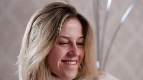 Smiling Woman with Blonde Hair in Casual Setting