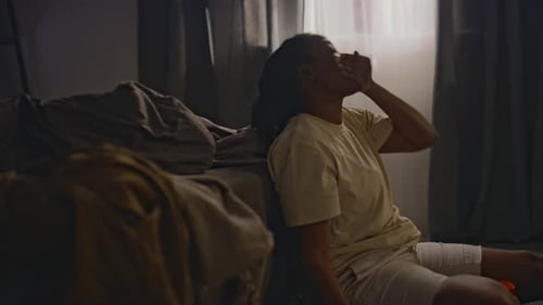 Woman Sitting Drinking Water Indoors in Bedroom