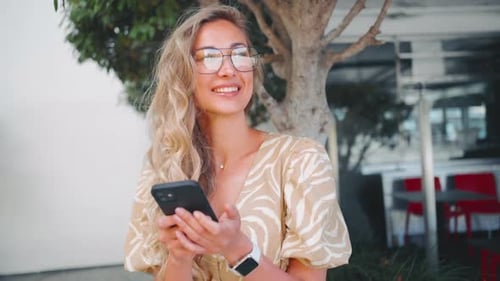 Woman With Blonde Hair Smiling and Using Phone
