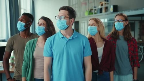 A Group of Young People are Wearing Masks While They Engage in a Modern Office Setting