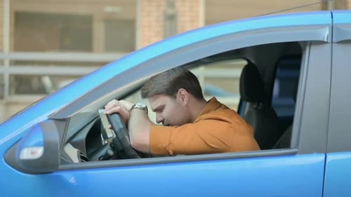 Man Leaning on Steering Wheel Inside Car