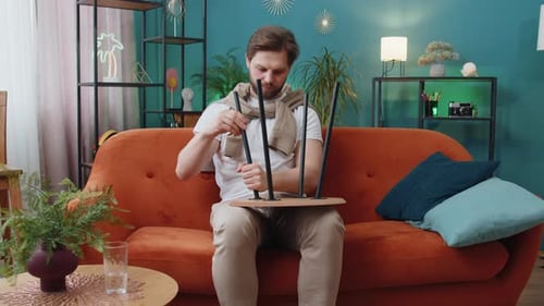 Man Assembling Furniture at Home on Couch