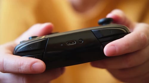 Hands Play Video Game with Black Controller