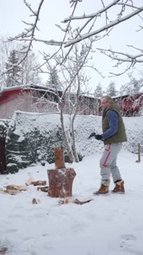 A Middleaged Man is Chopping Firewood