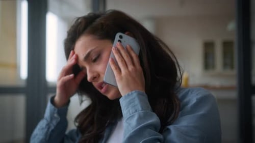 Woman on Phone Call Looking Stressed Indoors