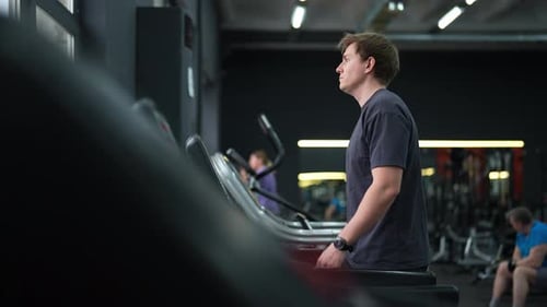 Side View Tracking Shot of Male Beginner in Outfit Walking on Treadmill Working on Health and