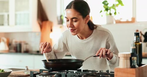 Woman Cooking Vegetables in a Bright Kitchen