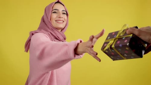 Happy Muslim Woman Smiling While Receiving a Gift