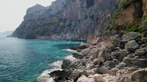 Boats with tourists wait for an adventure off a rocky coast